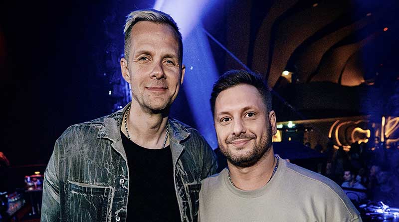 Adam Beyer y Mark Reeve posan juntos y sonríen en un club nocturno