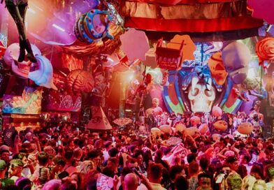Escenario de elrow decorado con motivos coloridos de la Noche de los Muertos, con el público bailando durante una sesión de música electrónica